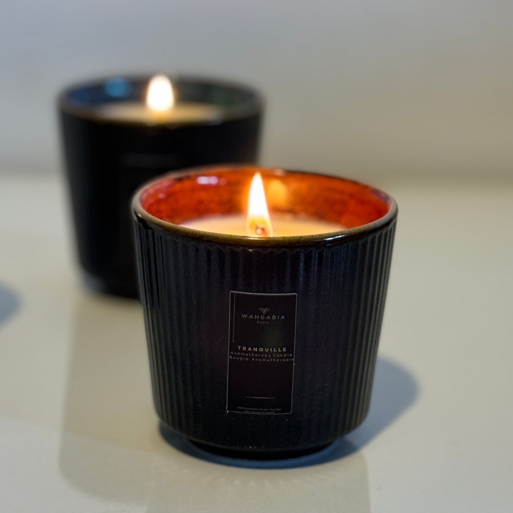 A close-up shot of an Alegre wellness candle with another in the background